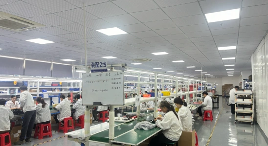 Workers performing precision structural assembly of device casings and internal components on dedicated production lines.